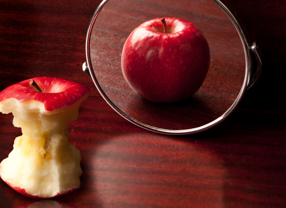 eaten apple looking in the mirror signifying body images issues