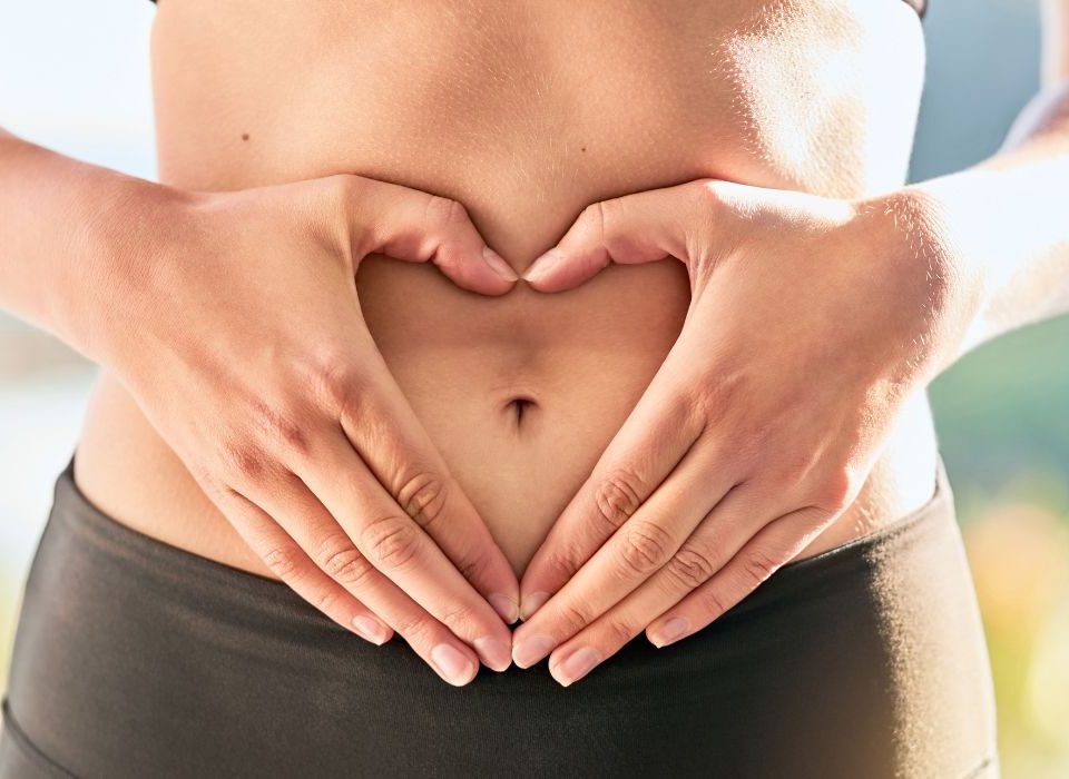 woman holding hands in a heart over stomach to depict body image and mental health