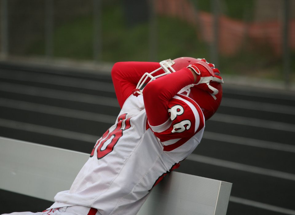 football player on the bench depressed following a loss