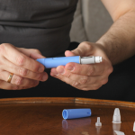 Man getting ready to inject a weight loss medicine