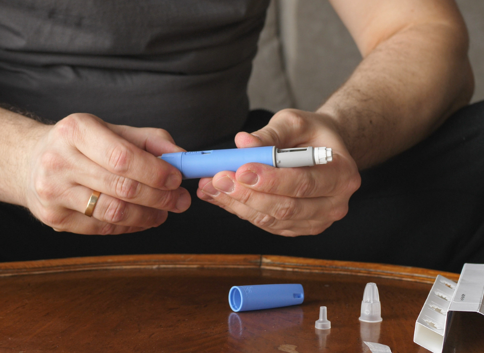 Man getting ready to inject a weight loss medicine