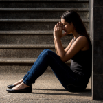 Woman sitting down upset, dealing with her body image issues