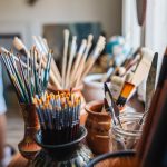 various paint brushes in jars