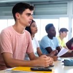 White high school teen male with his classmate paying attention to the teacher