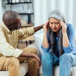 Older woman suffering from social anxiety being comforted by her husband