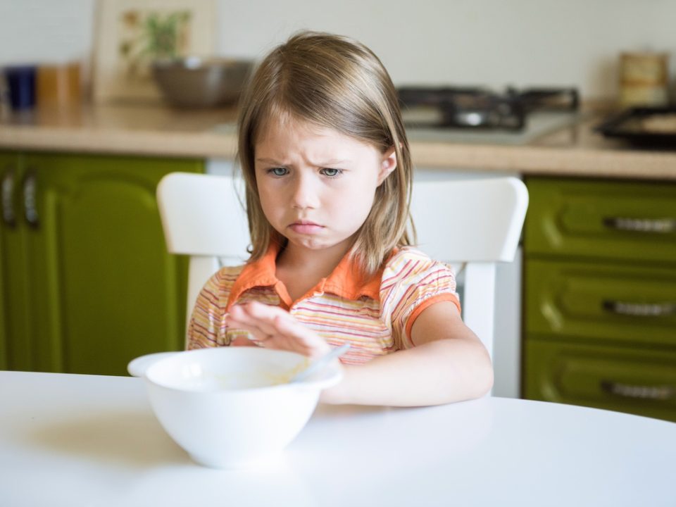 Female child pushing a bowl away dealing with arfid