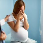depressed pregnant woman at doctor
