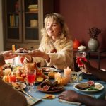 Young adult woman sitting at a table during Thanksgiving practicing mindful eating to avoid binge eating