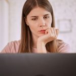 Woman looking up Anorexia signs and symptoms on her laptop