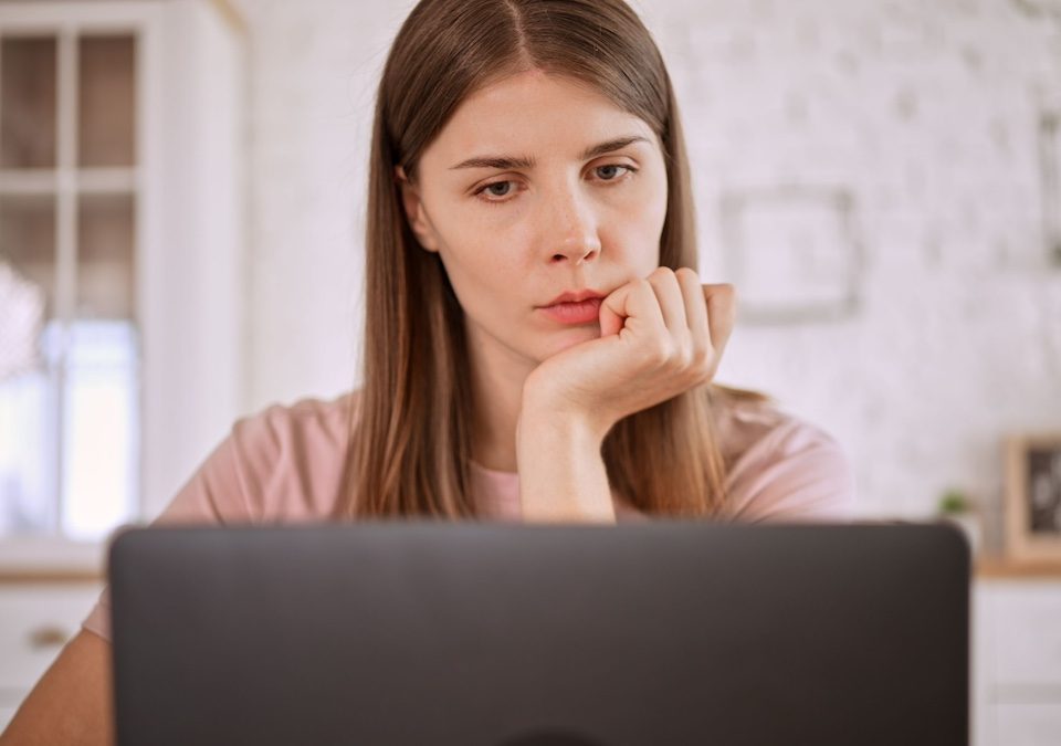 Woman looking up Anorexia signs and symptoms on her laptop