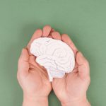 hands holding a brain drawn in pencil