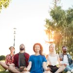 Group of adults sitting in yoga poses practicing mental wellness