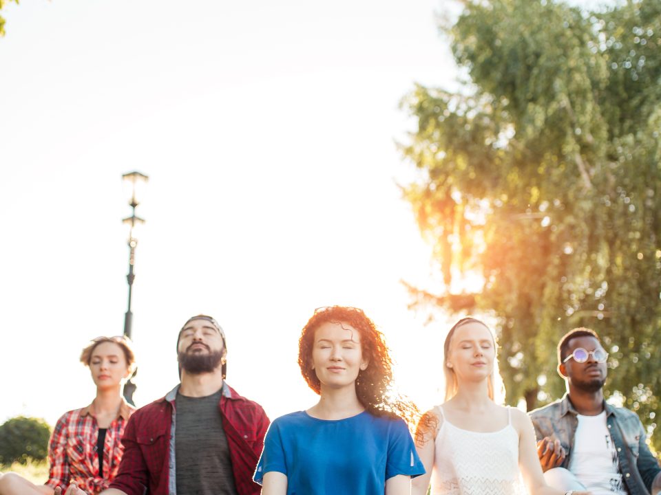 Group of adults sitting in yoga poses practicing mental wellness