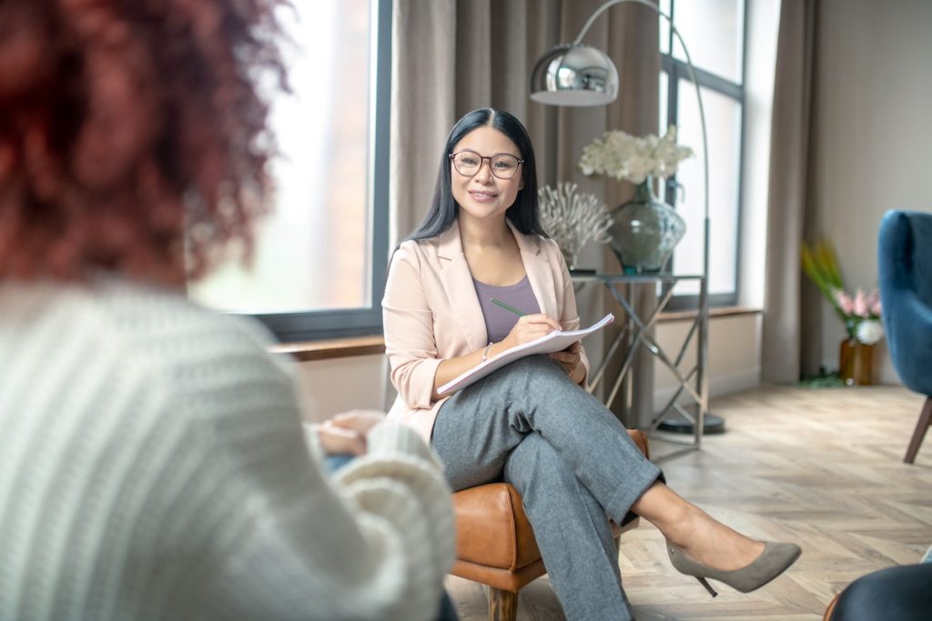 Therapist sitting with female client in a modern room