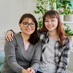 Adult and teen sitting side by side