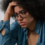 Young adult African American female upset over her binge eating disorder