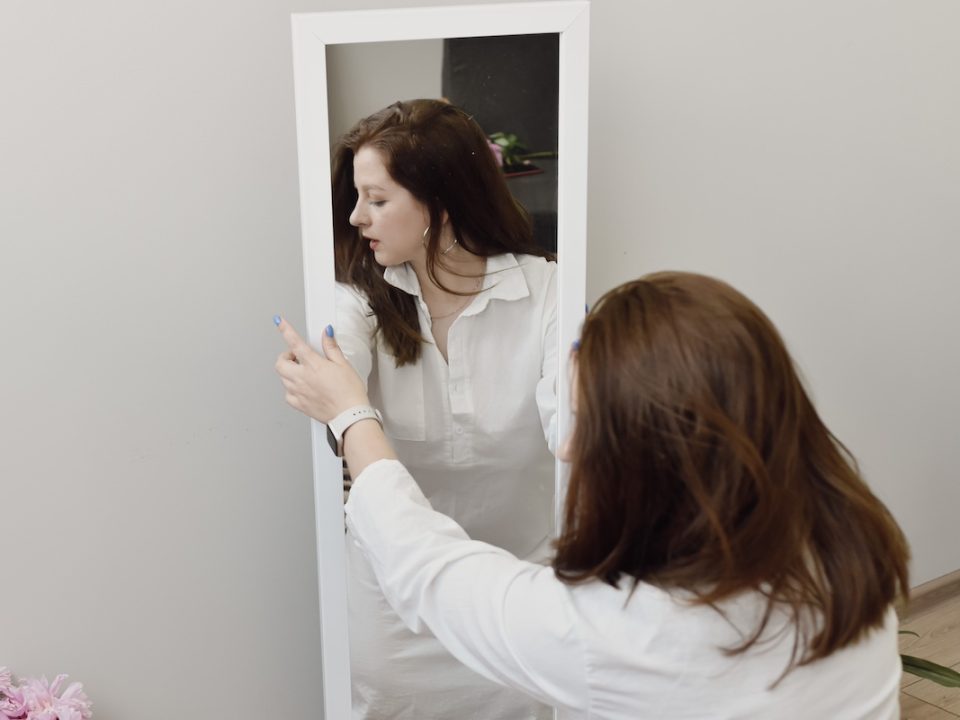 Women's reflection looking away from her in the mirror