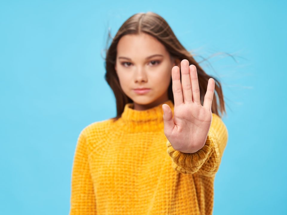 Young woman standing with her hand out as a symbol to avoid binge eating
