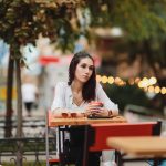 woman sitting alone at a table deep in thought