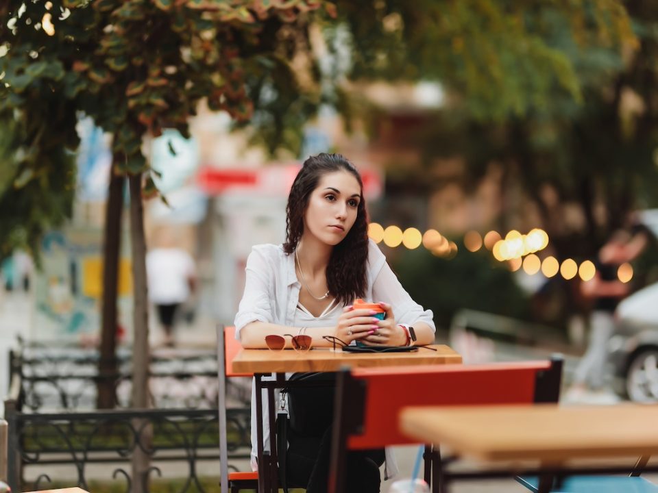 woman sitting alone at a table deep in thought