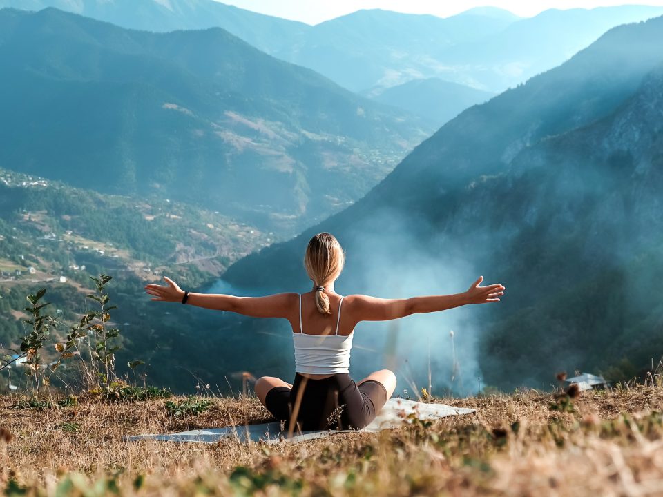 woman practicing yoga on a mountain